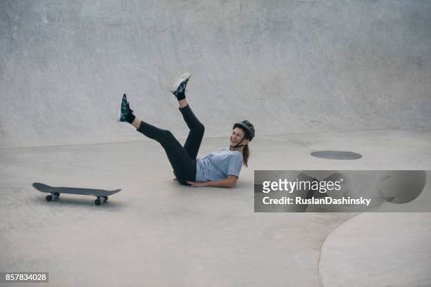 an active senior woman falling in while skateboard practice. - extreme skating stock pictures, royalty-free photos & images