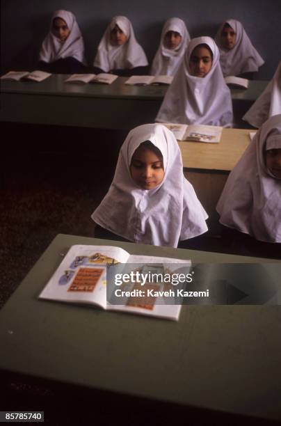 Young girls wearing Islamic hijab at Etefagh Primary School in Tehran, during Torah studies class, 19th October 1992. The books are printed by the...