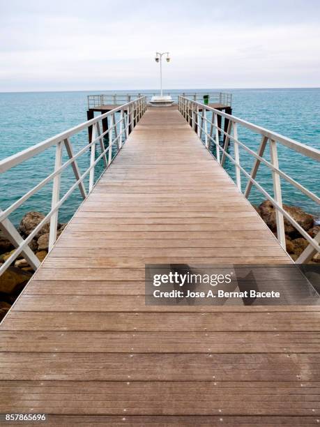 metallic bridge with wooden floor on the sea surface with a viewpoint. chilches, valencian community,  castellón /spain - つり革 ストックフォトと画像