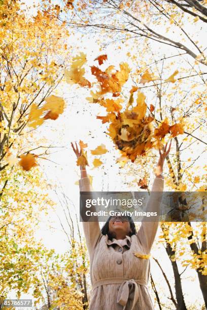 african american women throwing leaves - throwing leaves stock pictures, royalty-free photos & images