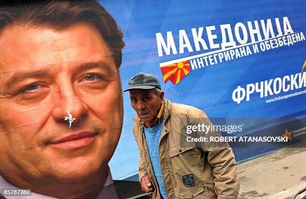 Man passes a large election billboard of the presidential candidate of the opposition SDSM party Ljubomir Frckoski in Skopje on April 3, 2009....