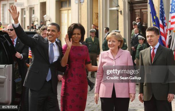 President Barack Obama and his wife Michelle wave upon their arrival as German Chancellor Angela Merkel and her husband Joachim Sauer look on before...