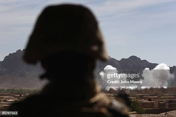 Marine watches a Marine HIMARS rocket attack on Taliban positions on April 3, 2009 in Now Zad in Helmand province, Afghanistan. American forces...