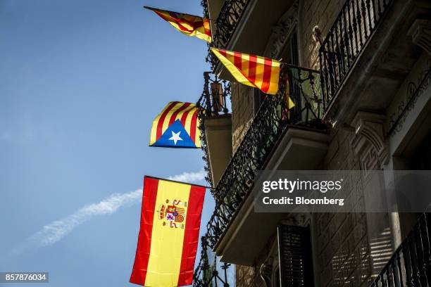 Flags in favour of Catalan independence, top, and a pro Spanish national flag, fly from the balconies of a building in Barcelona, Spain, on Thursday,...