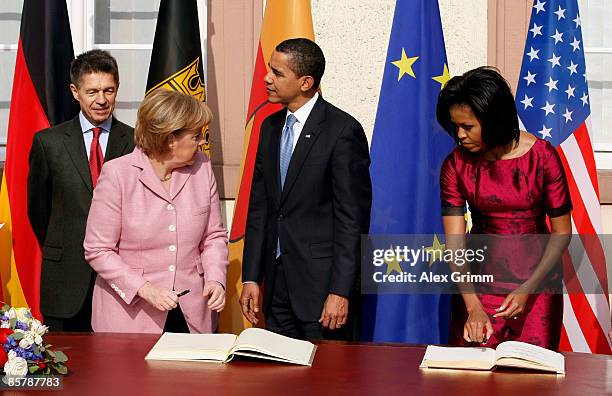 President Barack Obama , his wife Michelle , German Chancellor Angela Merkel and her husband Joachim Sauer sign the Golden Book of the city of Baden...