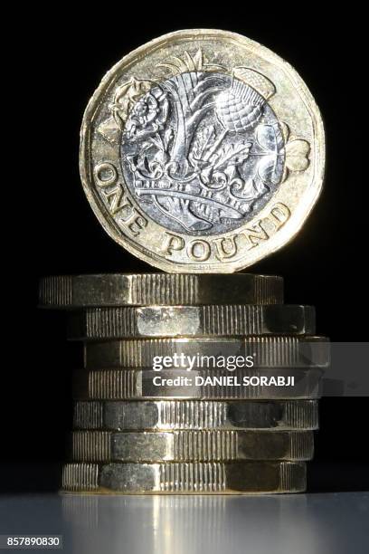 British one pound sterling coins are arranged for a photograph in central London on October 5, 2017. - The British pound was under pressure on...