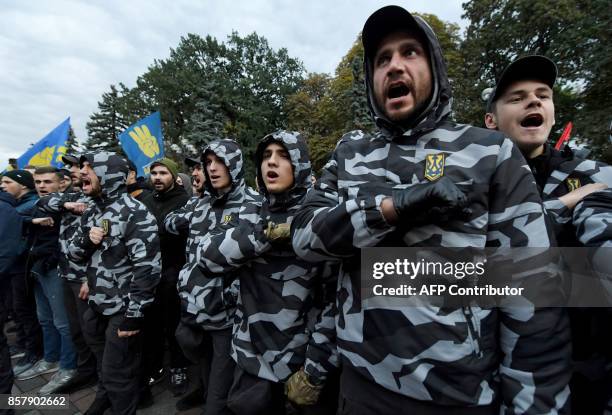 Ukrainian far-right parties activists gesture as they chant slogans during a demonstration in front of the Ukrainian Parliament during a session, in...