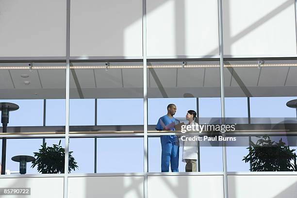 two doctors talking in corridor - hospital building stock-fotos und bilder