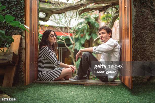 若い男と女の庭で一緒に座って