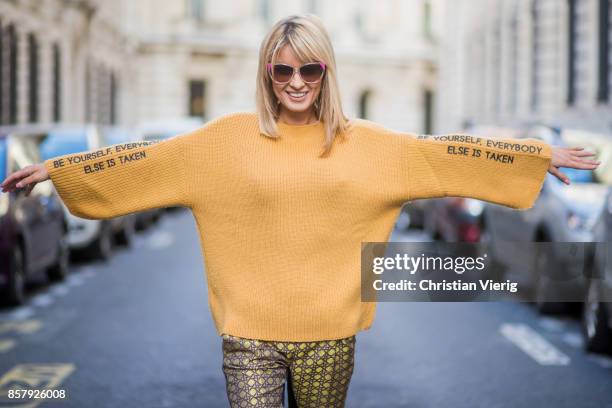 Gitta Banko wearing a mustard colored sweater from Mango with the print be yourself everybody else is taken, brocade jacket with fake fur trimming in...