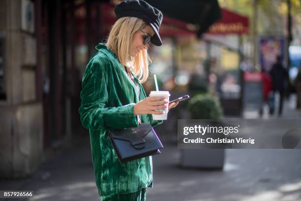 Gitta Banko with a Starbucks coffee to go and a phone texting wearing a green velvet suit by Jadicted, white cotton shirt by Dsquared 2, black sock...