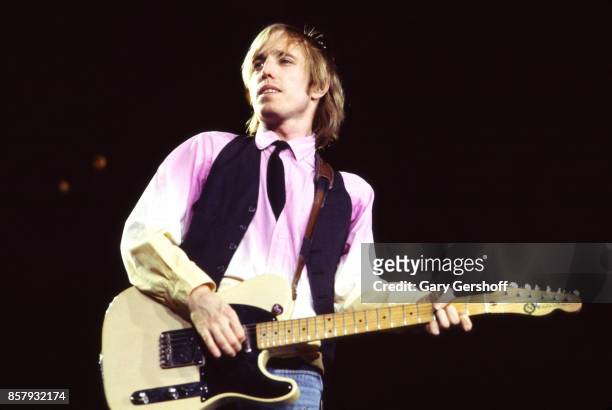 American Rock and Pop musician Tom Petty plays guitar as he leads his band, the Heartbreakers, during a performance on the 'Long After Dark' tour at...