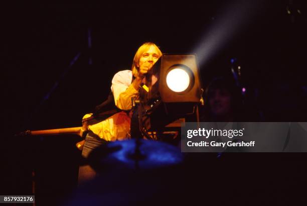 American Rock and Pop musician Tom Petty aims a spotlight as he leads his band, the Heartbreakers, during a performance on the 'Long After Dark' tour...