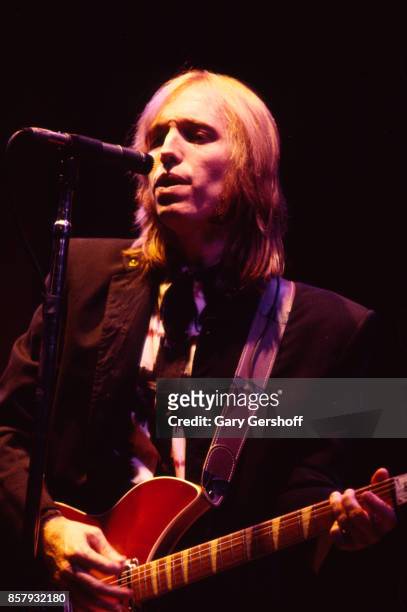 American Rock and Pop musician Tom Petty plays guitar as he leads his band, the Heartbreakers, during a performance on the 'Southern Accents' tour at...