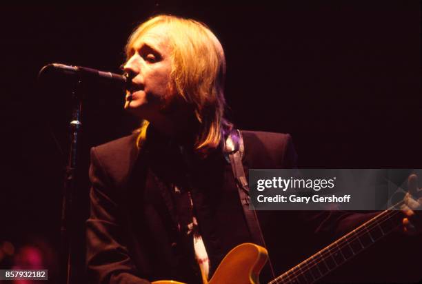 American Rock and Pop musician Tom Petty plays guitar as he leads his band, the Heartbreakers, during a performance on the 'Southern Accents' tour at...