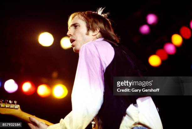 American Rock and Pop musician Tom Petty plays guitar as he leads his band, the Heartbreakers, during a performance on the 'Long After Dark' tour at...
