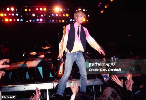 American Rock and Pop musician Tom Petty shakes hands with fans as he leads his band, the Heartbreakers, during a performance on the 'Long After...