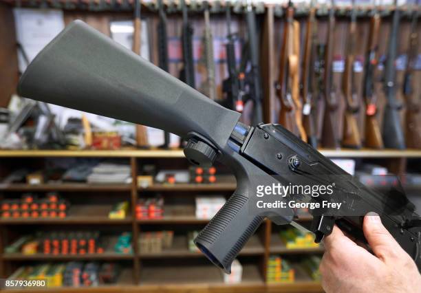 Bump stock device , that fits on a semi-automatic rifle to increase the firing speed making it similar to a fully automatic rifle, is installed on a...