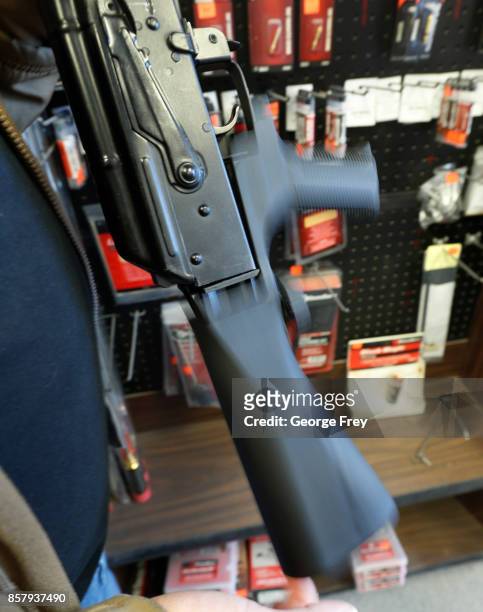 The motion of a bump stock device as shown here on a AK-47 semi-automatic rifle to increase the firing speed, making it similar to a fully automatic...