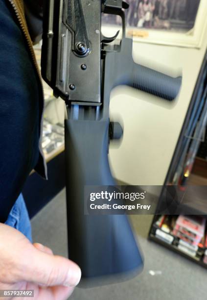 The motion of a bump stock device as shown here on a AK-47 semi-automatic rifle to increase the firing speed, making it similar to a fully automatic...