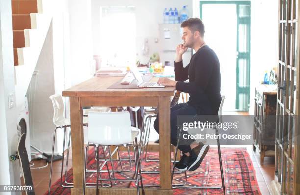 a young man working on his laptop from home. - good posture fotografías e imágenes de stock