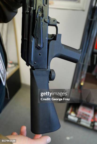 Bump stock device that fits on a semi-automatic rifle to increase the firing speed, making it similar to a fully automatic rifle, is installed on a...
