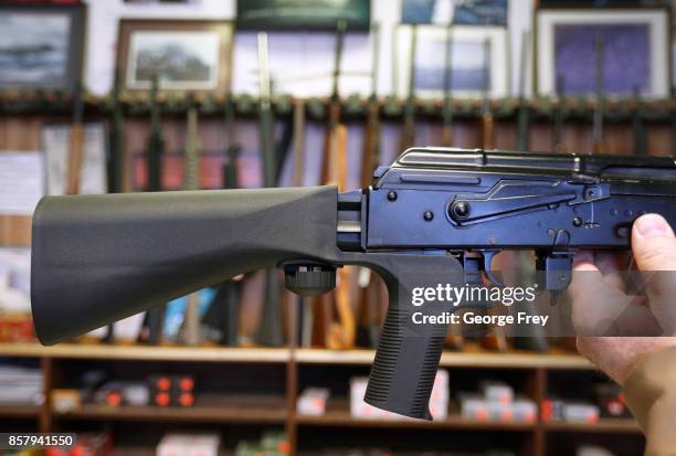 Bump stock device that fits on a semi-automatic rifle to increase the firing speed, making it similar to a fully automatic rifle, is installed on a...