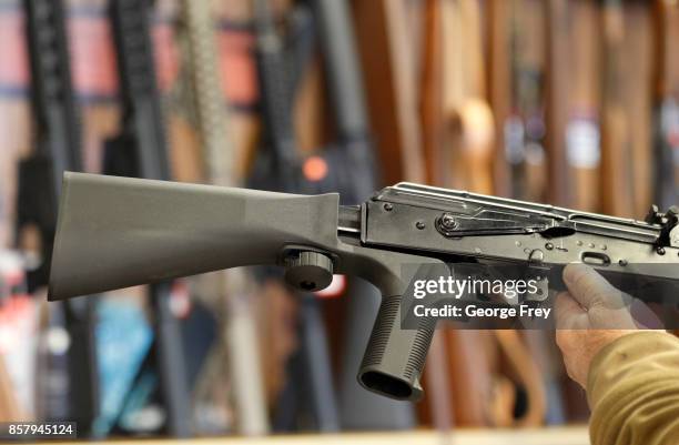 Bump stock device, that fits on a semi-automatic rifle to increase the firing speed, making it similar to a fully automatic rifle, is installed on a...