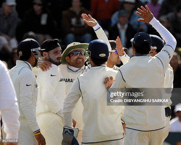 Indian cricketers congratulate teammate Harbhajan Singh for taking the wicket of New Zealand batsman James Franklind uring the second day of the...