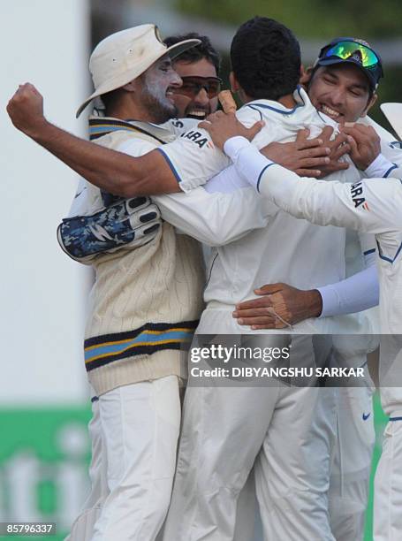 Indian cricketers Mahendra Singh Dhoni Harbhajan Singh and Yuvraj Singh congratulate bowler Zaheer Khan for taking the wicket of New Zealand batsman...