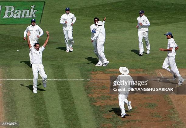 Indian cricketer Zaheer Khan with teammates celebrate the wicket of unseen New Zealand batsmans Jesse Ryder during the second day of the final Test...