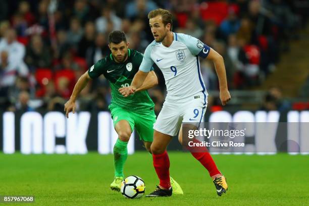 Harry Kane of England is watched by Bojan Jokic of Slovenia during the FIFA 2018 World Cup Group F Qualifier between England and Slovenia at Wembley...