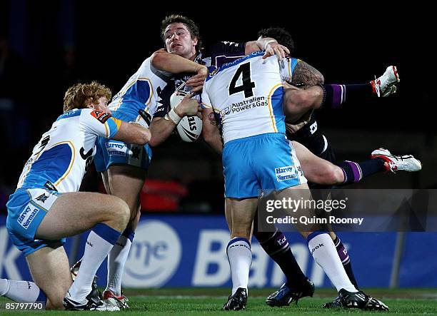 Anthony Quinn of the Storm is tackled by Brett Delaney of the Titans during the round four NRL match between the Melbourne Storm and the Gold Coast...