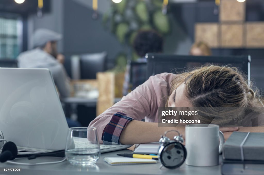 Jonge vrouw in slaap op het werk