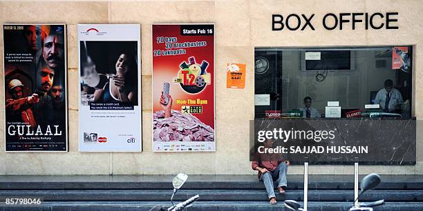An Indian man sits on the steps of a box office of a multiplex cinema in Mumbai on April 4, 2009. Bollywood film producers went on strike on April 4,...