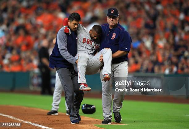 Eduardo Nunez of the Boston Red Sox is carried off the field by Red Sox trainer Masai Takahashi and manager John Farrell after suffering an injury in...