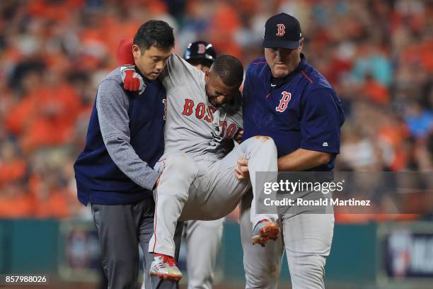 Eduardo Nunez of the Boston Red Sox is carried off the field by Red Sox trainer Masai Takahashi and manager John Farrell after suffering an injury in...