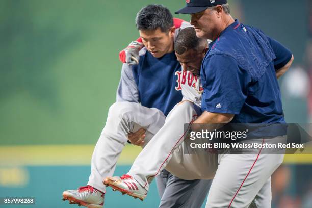 Manager John Farrell and trainer Masai Takahashi tend to Eduardo Nunez of the Boston Red Sox after he was injured while running up the first base...
