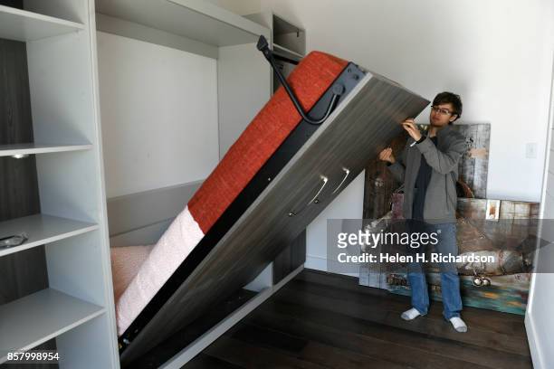 Alex Sundt, of the University of California, Berkeley, puts up a murphy bed so he can move the wall to the right up against it to create more space...