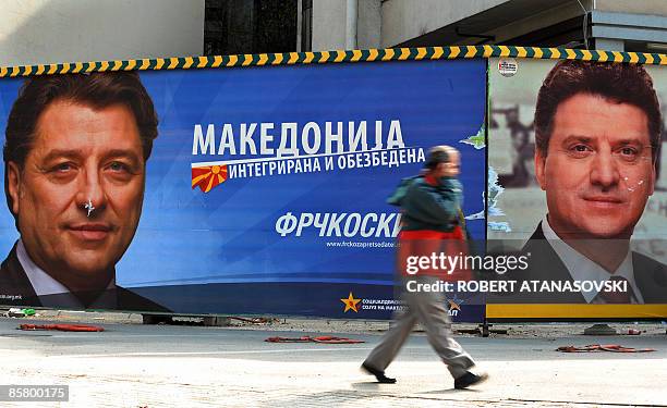 Man walks past a large election billboard of the presidential candidate of the ruling VMRO DPMNE party George Ivanov and the opposition SDSM party...