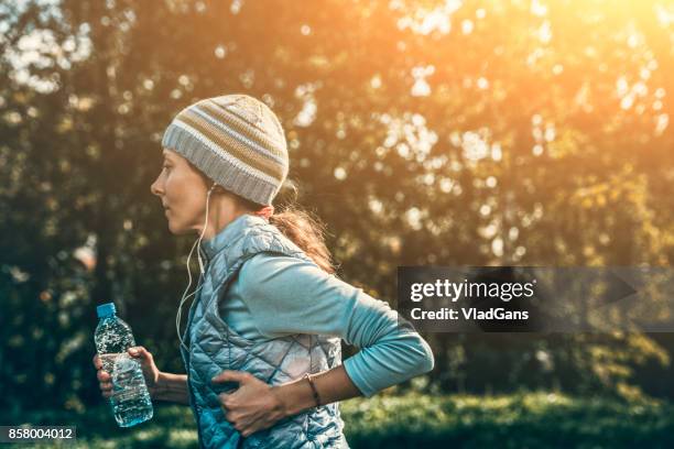 woman running on stadium track - amateur sport stock pictures, royalty-free photos & images