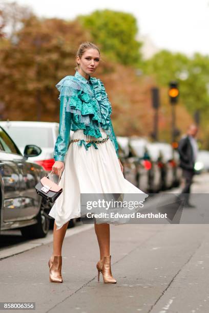 Landiana wears a blue lace ruffle top, a white skirt, heels shoes, outside Valentino, during Paris Fashion Week Womenswear Spring/Summer 2018, on...