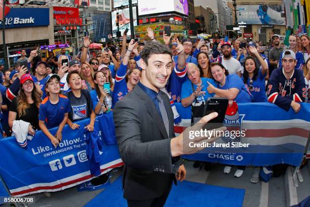 Chris Kreider of the New York Rangers takes a photo with fans as he walks the Blue Carpet prior to the home opener against the Colorado Avalanche at...