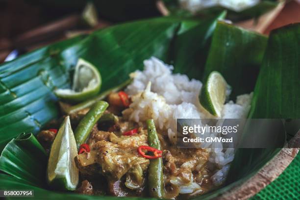 balinese pork curry dish with jasmine rice served on banana leave - balinese culture stock pictures, royalty-free photos & images