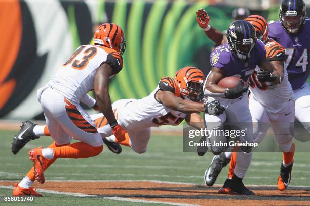 Javorius Allen of the Baltimore Ravens runs the football upfield against Vincent Rey of the Cincinnati Bengals during their game at Paul Brown...