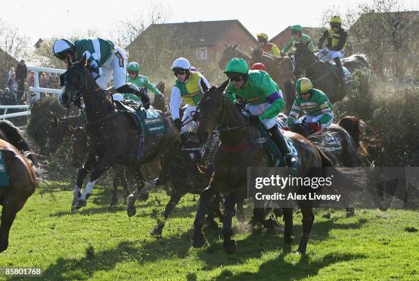 Mon Mome ridden by Liam Treadwell clears Becher's Brook as Nick Scholfield attempts to hang on to Cornish Sett on their way to victory in the John...