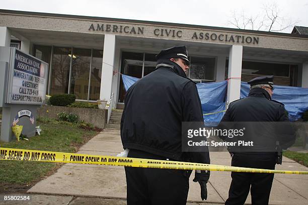 Police officers stand in front of the American Civic Association where a gunman killed 13 people yesterday April 4, 2009 in Binghamton, New York. The...