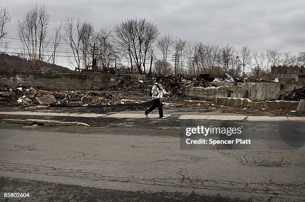 Teen walks by a destroyed building April 4, 2009 in economically depressed Binghamton, New York. A gunman killed 13 people in an immigration...