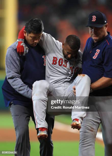 Eduardo Nunez of the Boston Red Sox is carried off the field by Red Sox trainer Masai Takahashi and manager John Farrell after suffering an injury in...