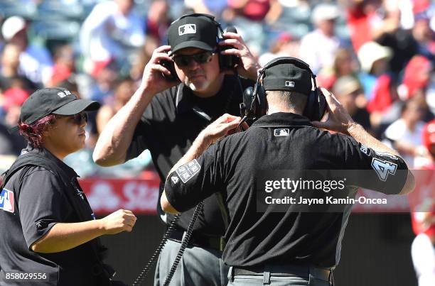 Umpire Ron Kulpa and umpire Jerry Meals listen on head phones for the call on a challenged play in the game between the Los Angeles Angels of Anaheim...